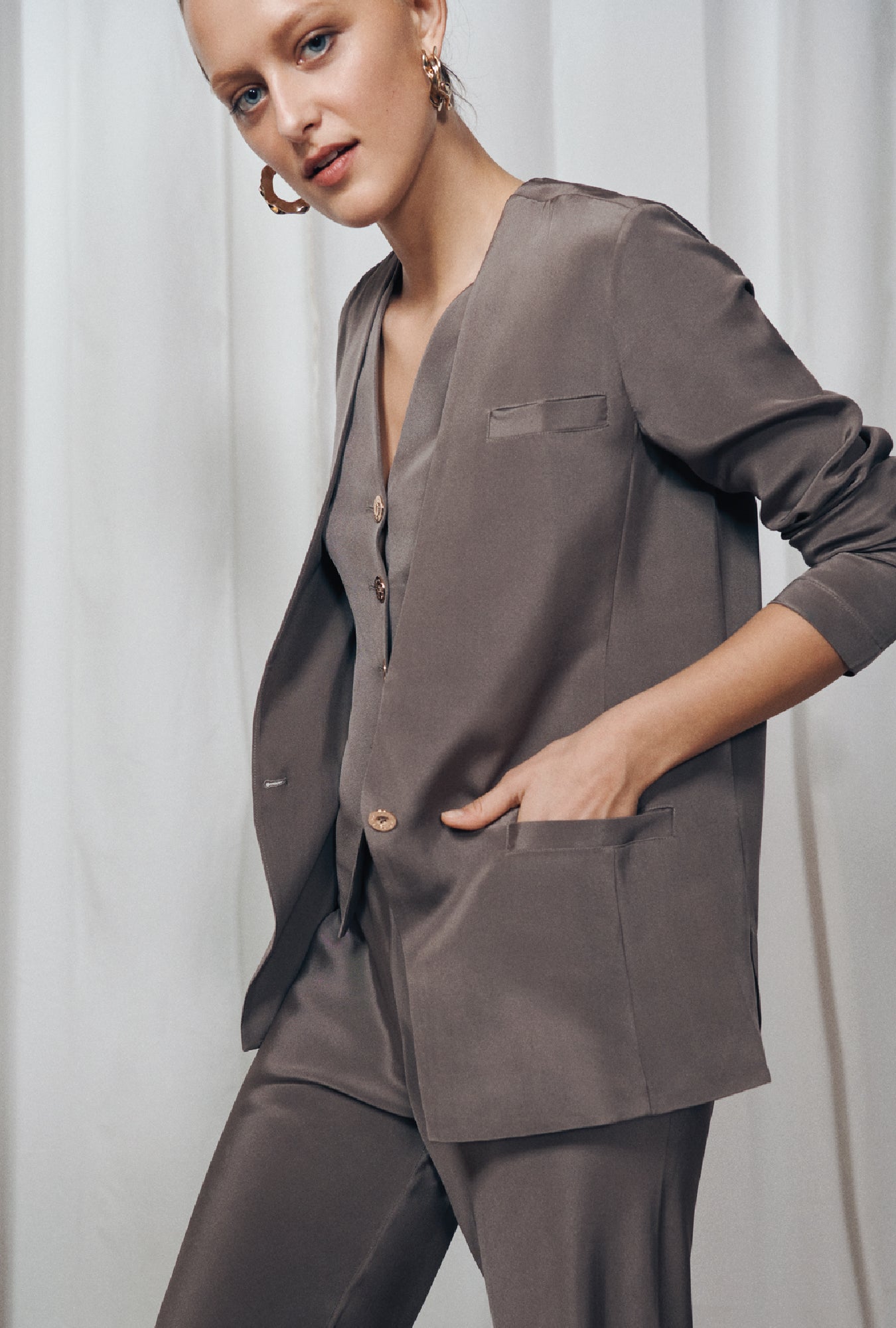 Image of a model wearing Outerwear. Product name - CDC Collarless Blazer Cinder in Cinder colour by brand - Silk Laundry