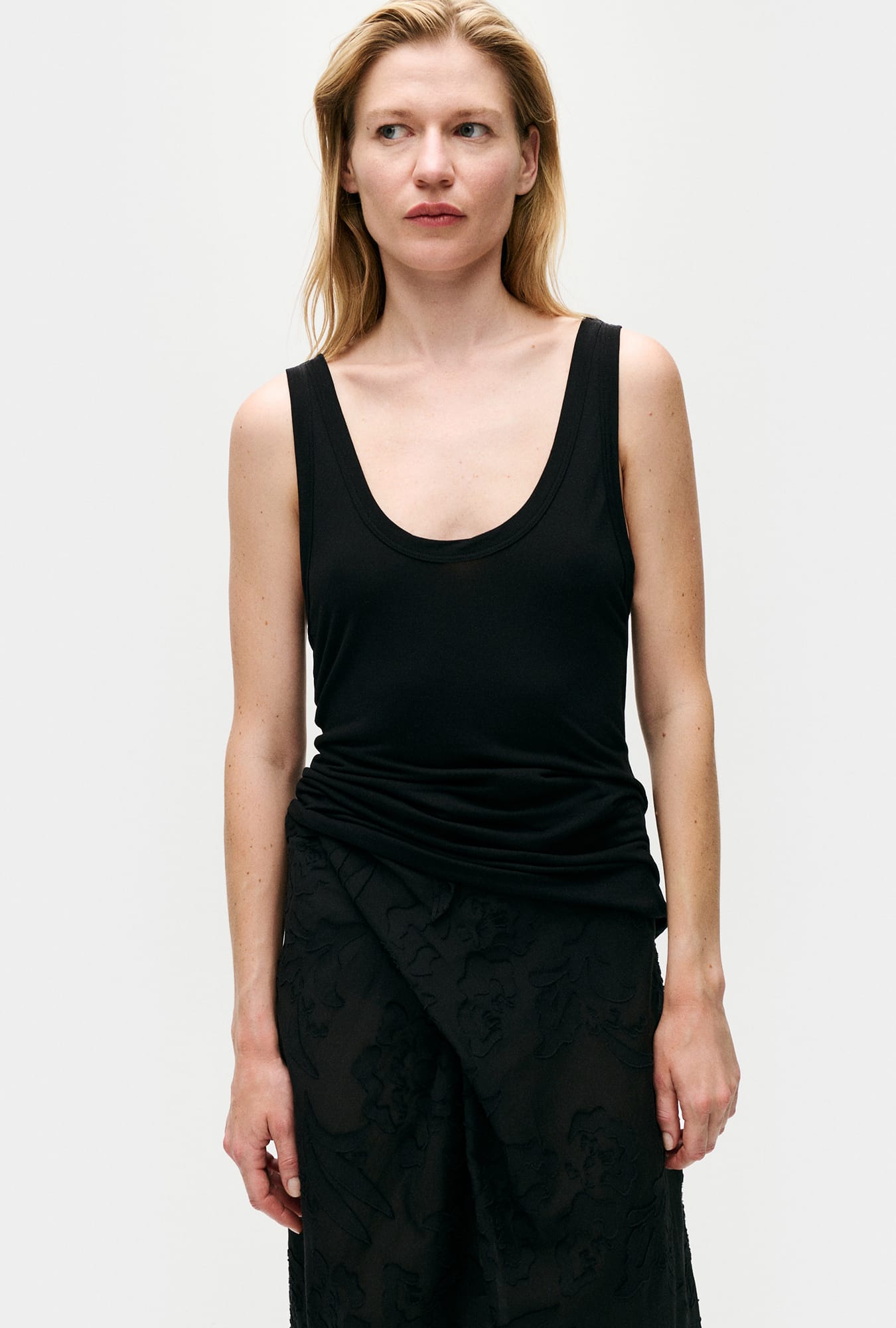 Image of a model wearing Tops. Product name - Jersey Modal Scoop Tank Black in Black colour by brand - Silk Laundry