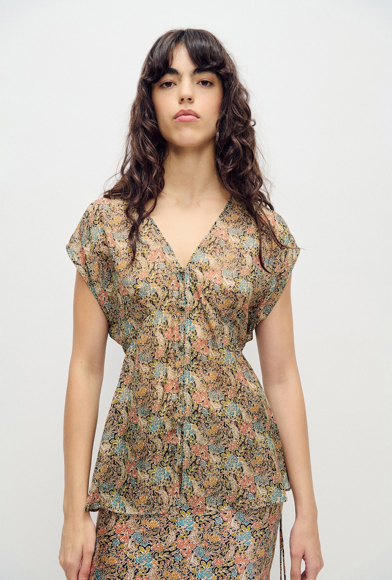 Image of a model wearing Tops. Product name - Chiffon V-Neck Top Sugar Floral in Sugar Floral colour by brand - Silk Laundry
