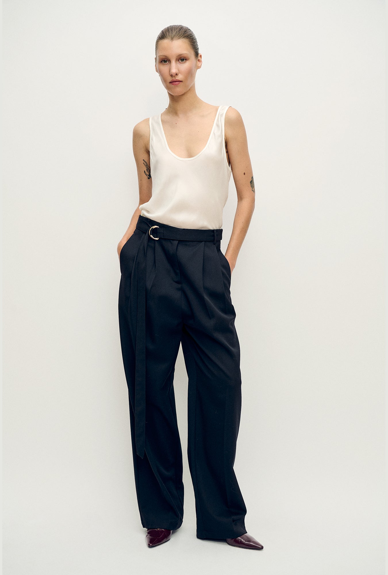 Image of a model wearing Tops. Product name - Scoop Neck Tank White in White colour by brand - Silk Laundry