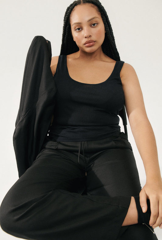 Image of a model wearing Tops. Productname: Silk Laundry RIBBED TANK in Black colour by brand - Silk Laundry