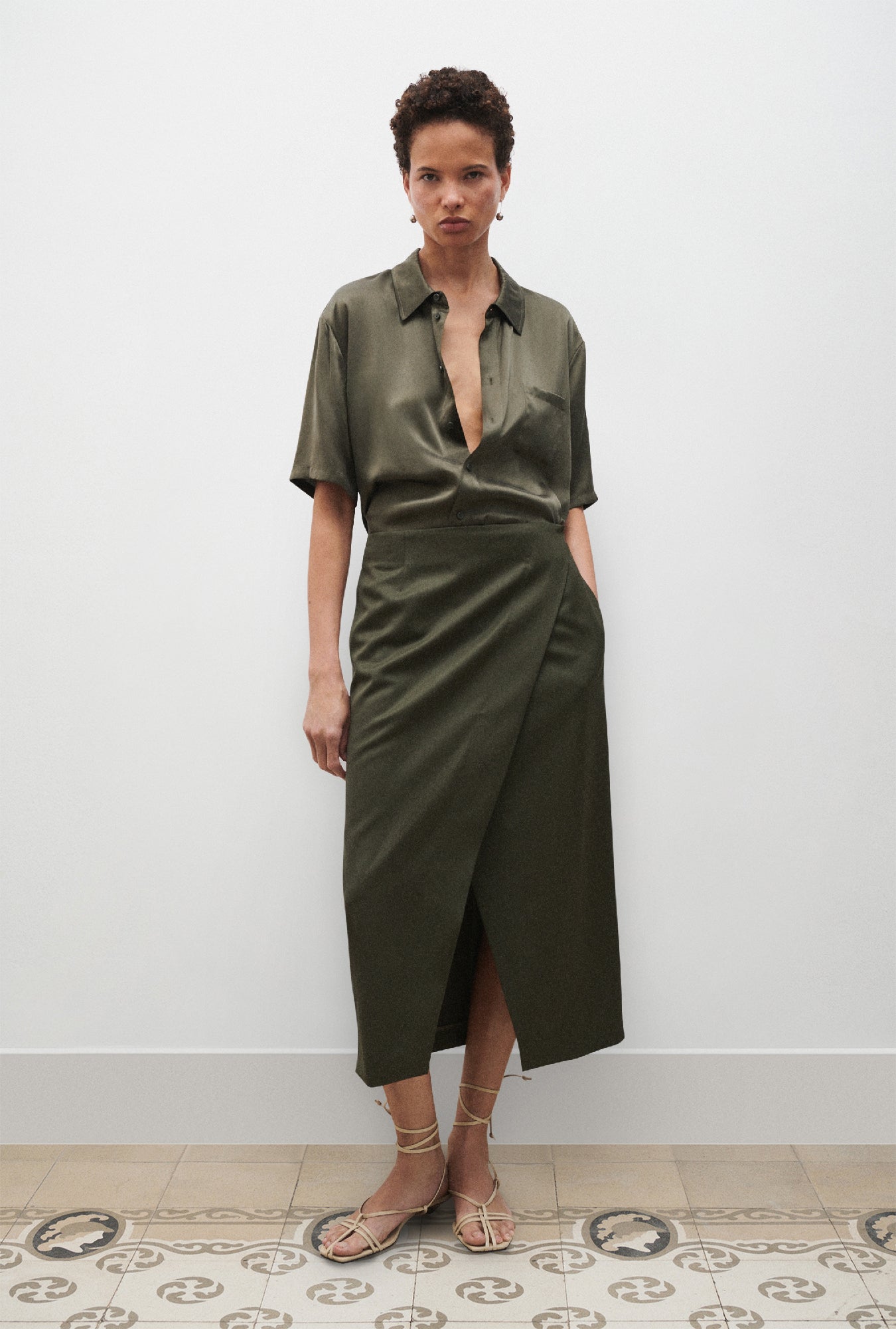 Image of a model wearing Tops. Product name - Short Sleeve Boyfriend Shirt Pine in Pine colour by brand - Silk Laundry