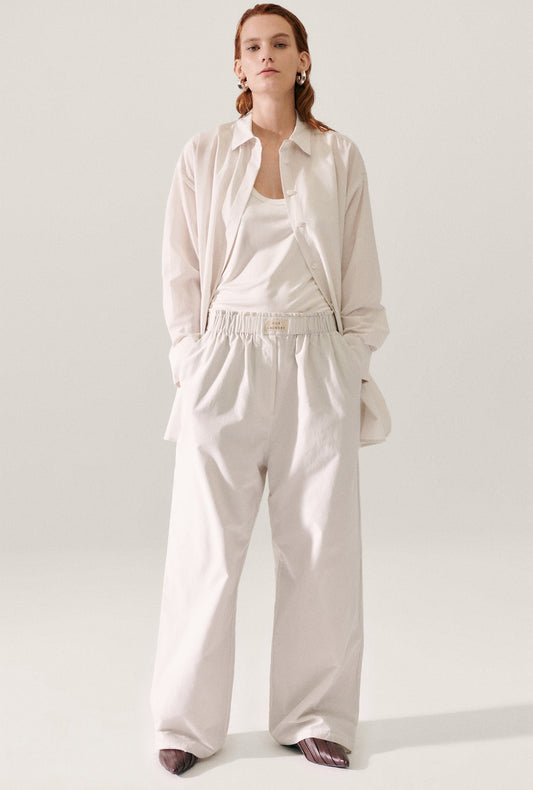 Image of a model wearing Pants. Product name - Cotton Silk Paper Bag Pants Dust in Dust colour by brand - Silk Laundry