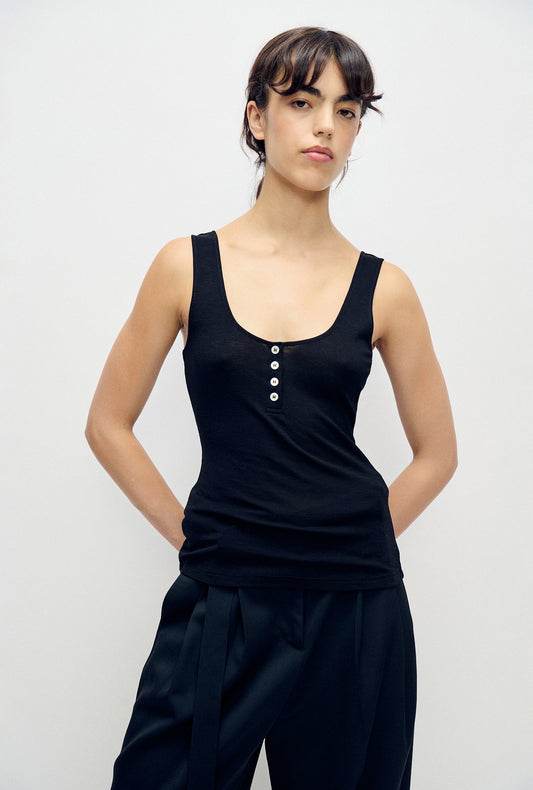 Image of a model wearing Tops. Product name - Merino Henley Tank Black in Black colour by brand - Silk Laundry