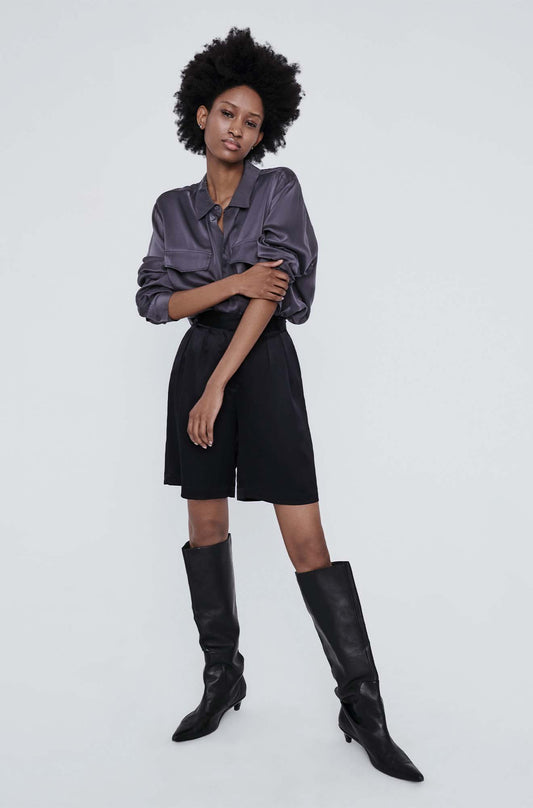Image of a model wearing Shorts. Product name - Double Pleated Shorts Black in Black colour by brand - Silk Laundry