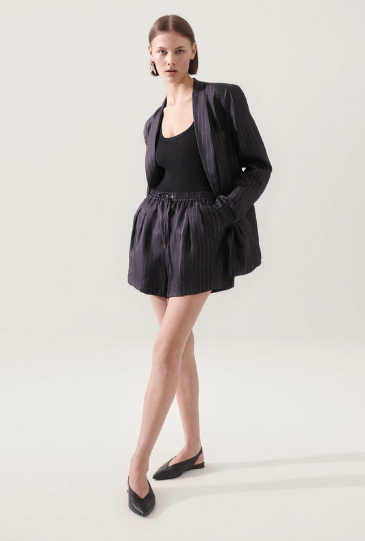 Image of a model wearing Shorts. Product name - Twill Slouch Shorts Pinstripe Black / White in Pinstripe Black/White colour by brand - Silk Laundry