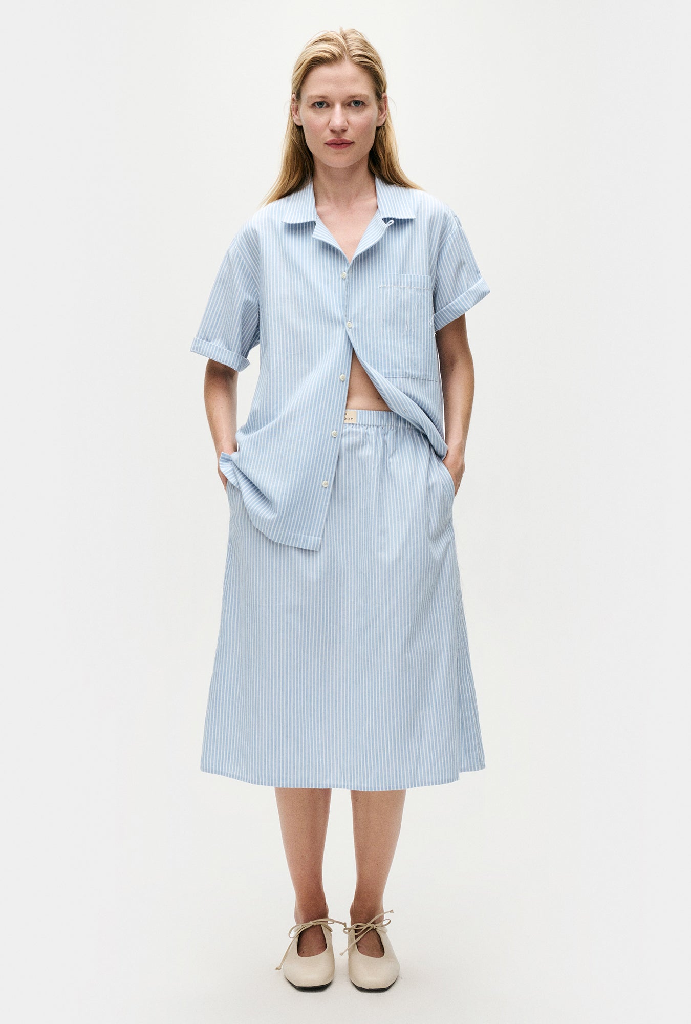 Image of a model wearing Skirts. Product name - Cotton Midi Skirt Storm Stripe in Storm Stripe colour by brand - Silk Laundry