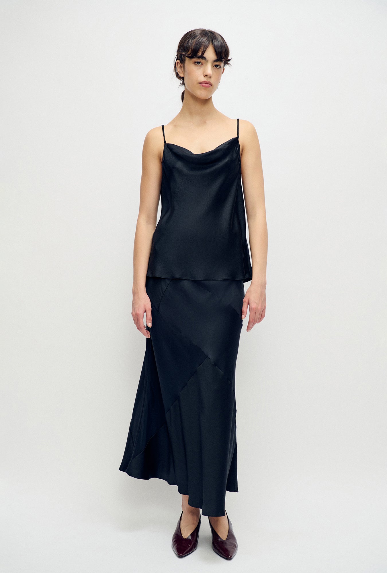 Image of a model wearing Tops. Product name - Hammered Drape Cami Black in Black colour by brand - Silk Laundry