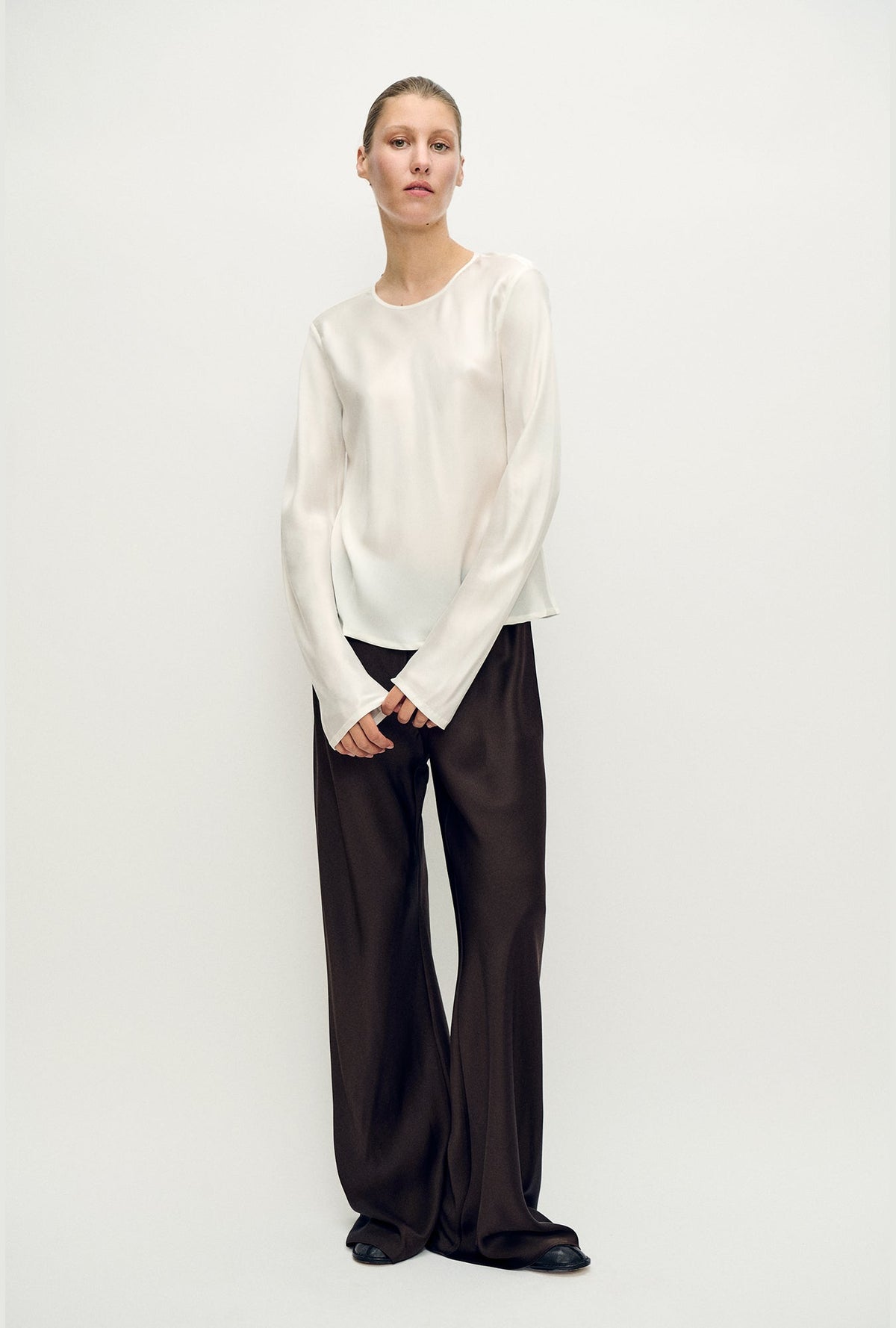 Image of a model wearing Tops. Product name - Long Sleeve Bias Top White in White colour by brand - Silk Laundry