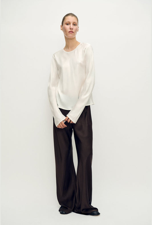 Image of a model wearing Tops. Product name - Long Sleeve Bias Top White in White colour by brand - Silk Laundry