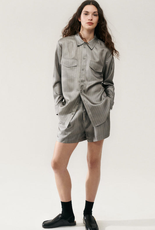Image of a model wearing Shorts. Product name - Twill Slouch Shorts Moon Pinstripe in Moon Pinstripe colour by brand - Silk Laundry