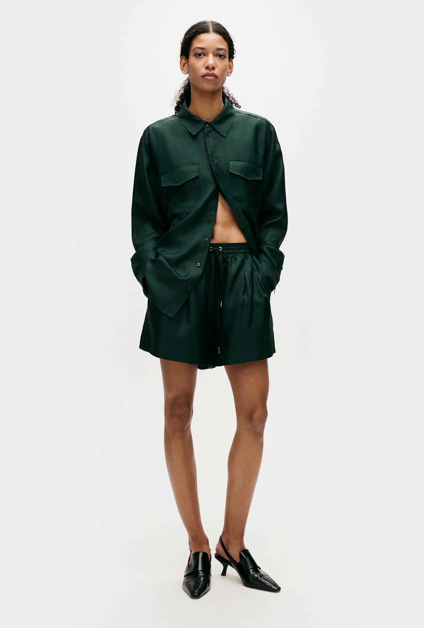 Image of a model wearing Shorts. Product name - Twill Slouch Shorts Scarab in Scarab colour by brand - Silk Laundry