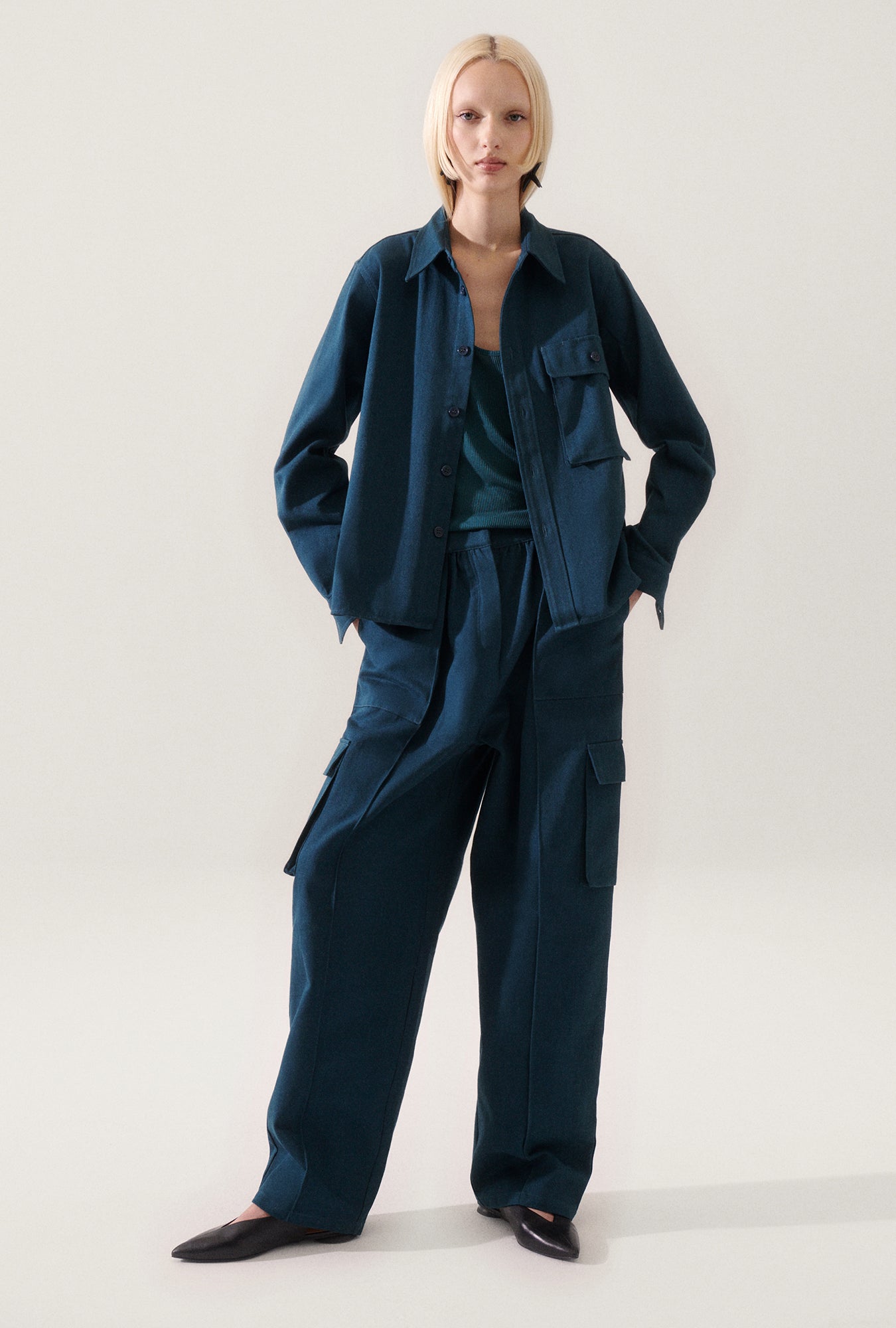 Image of a model wearing Outerwear. Product name - Canvas Overshirt Teal in Teal colour by brand - Silk Laundry