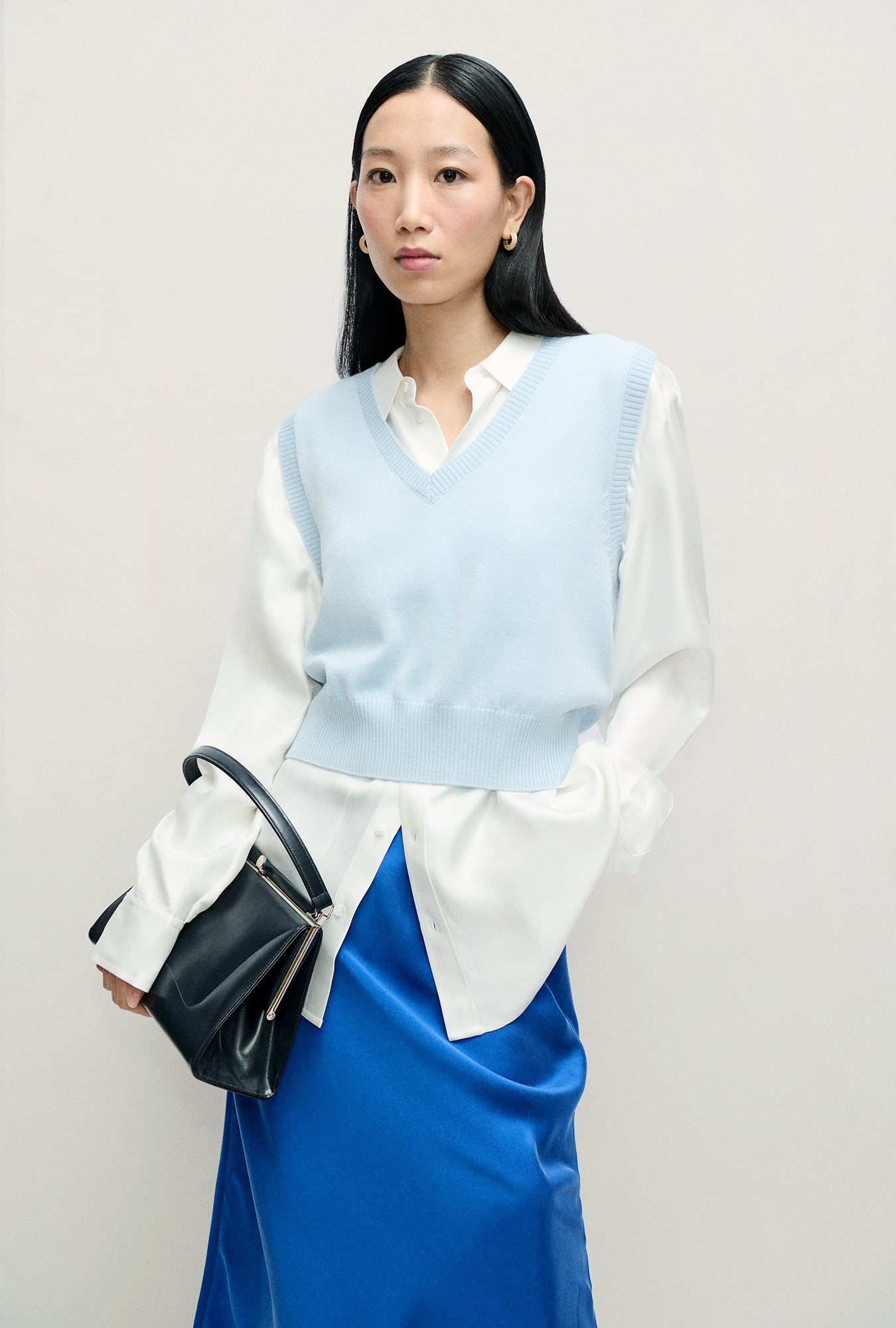 Image of a model wearing Outerwear. Product name - Wool V-Neck Sweater Vest Cornflower in Cornflower colour by brand - Silk Laundry