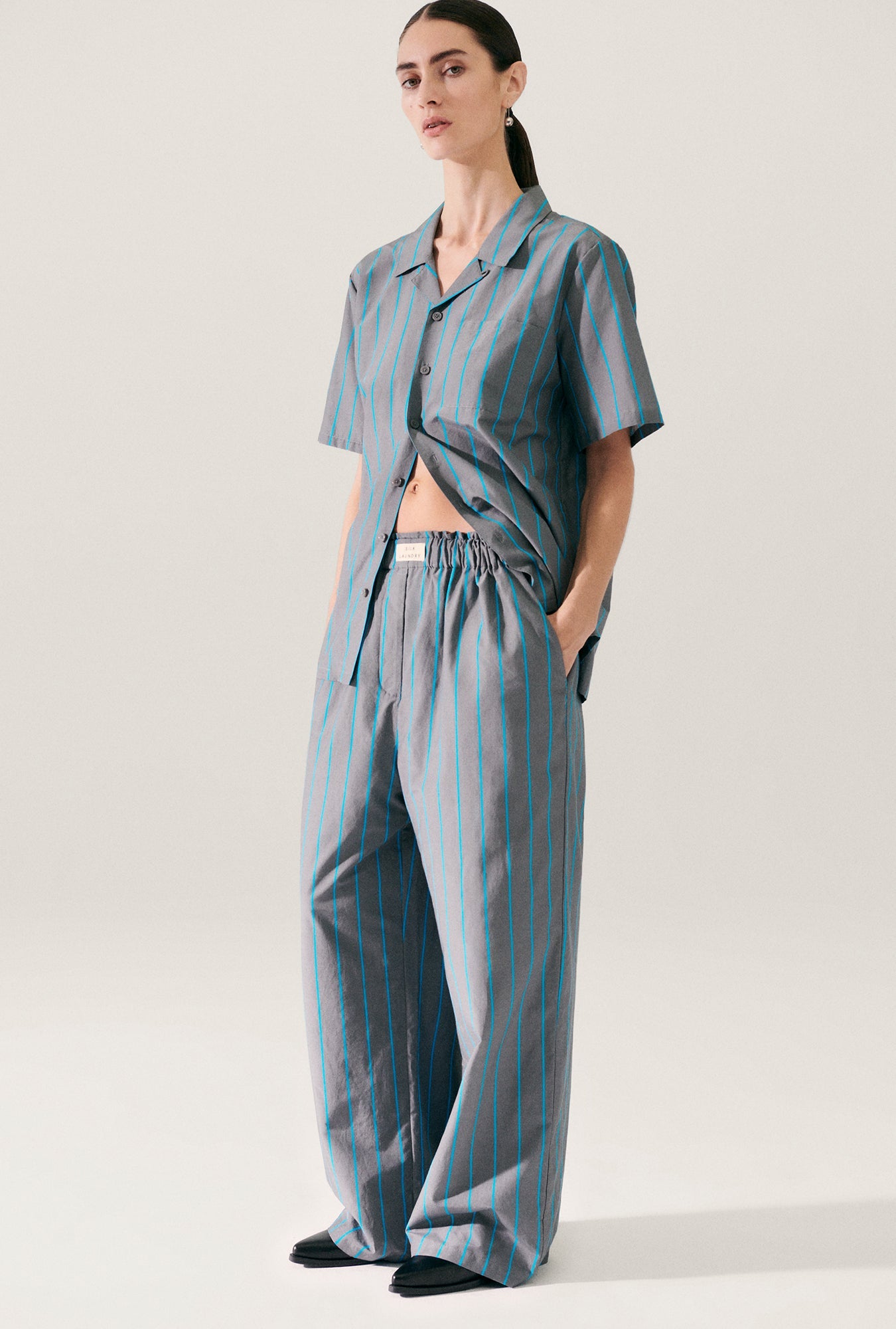 Image of a model wearing Pants. Product name - Cotton Silk Paper Bag Pants Oxygen Stripe in Oxygen Stripe colour by brand - Silk Laundry