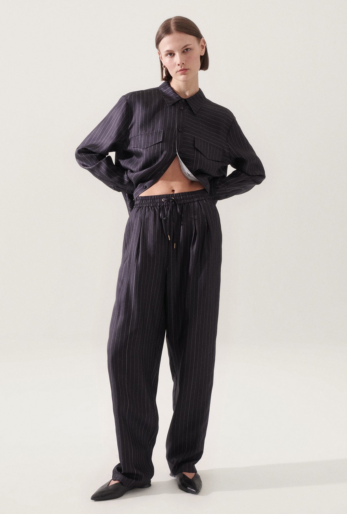 Image of a model wearing Pants. Product name - Twill Slouch Pants Pinstripe Black / White in Pinstripe Black/White colour by brand - Silk Laundry