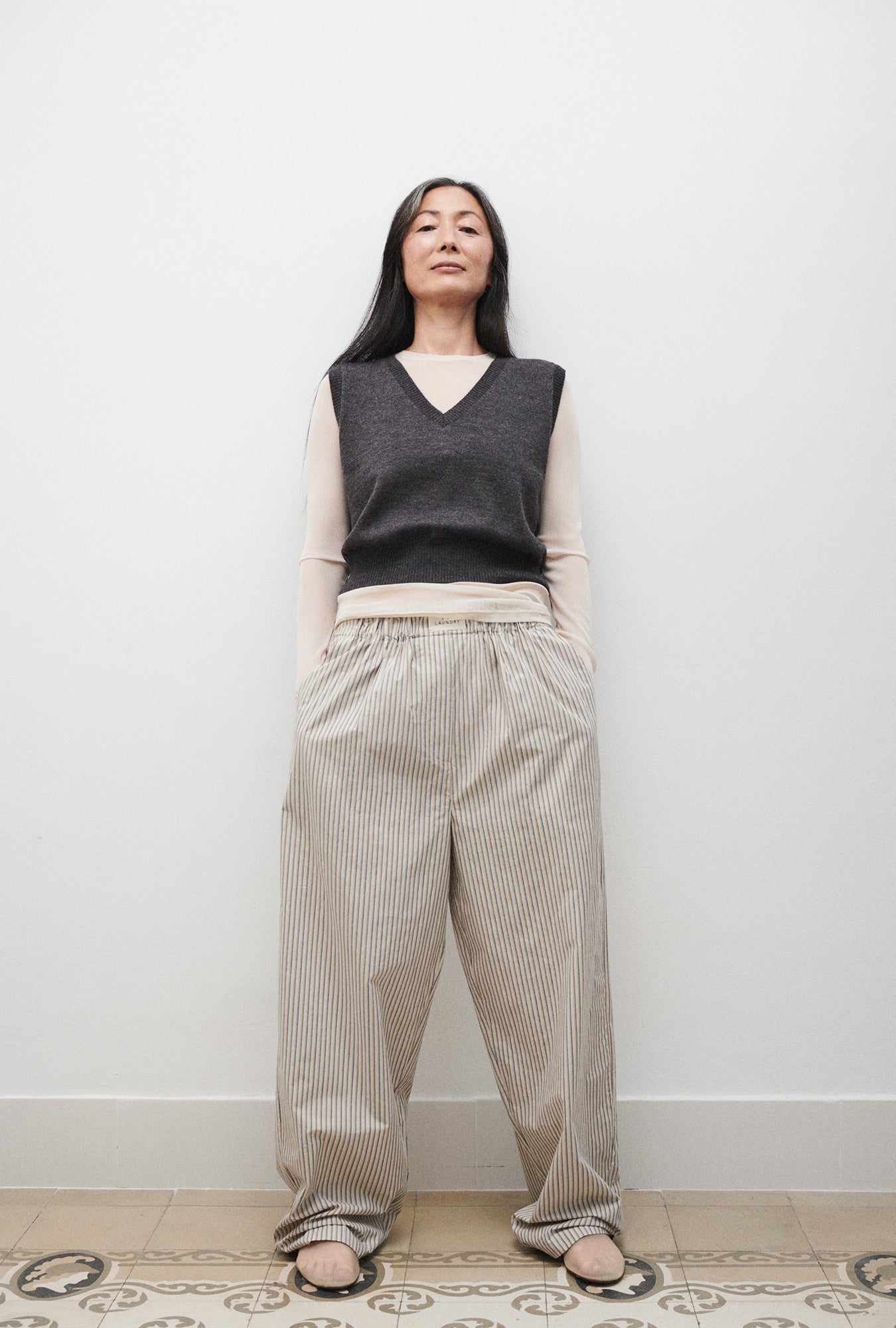 Image of a model wearing Outerwear. Product name - V-Neck Sweater Vest Granite Melange in Granite Melange colour by brand - Silk Laundry