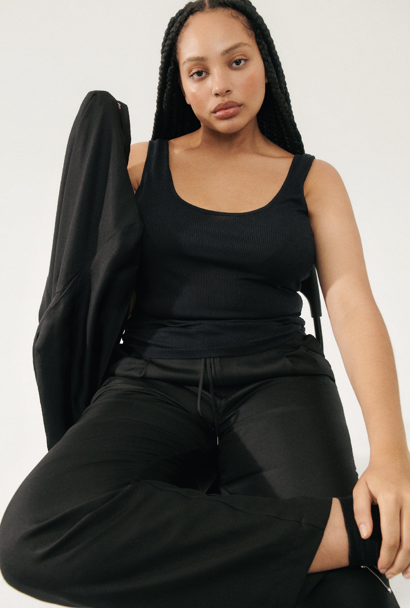 Image of a model wearing Tops. Product name - Ribbed Tank Black in Black colour by brand - Silk Laundry