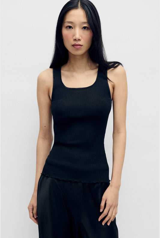 Image of a model wearing Tops. Product name - Silk Wool Ribbed Essential Tank Black in Black colour by brand - Silk Laundry