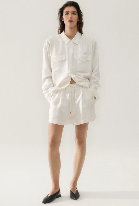 Image of a model wearing Shorts. Product name - Twill Slouch Shorts White in White colour by brand - Silk Laundry