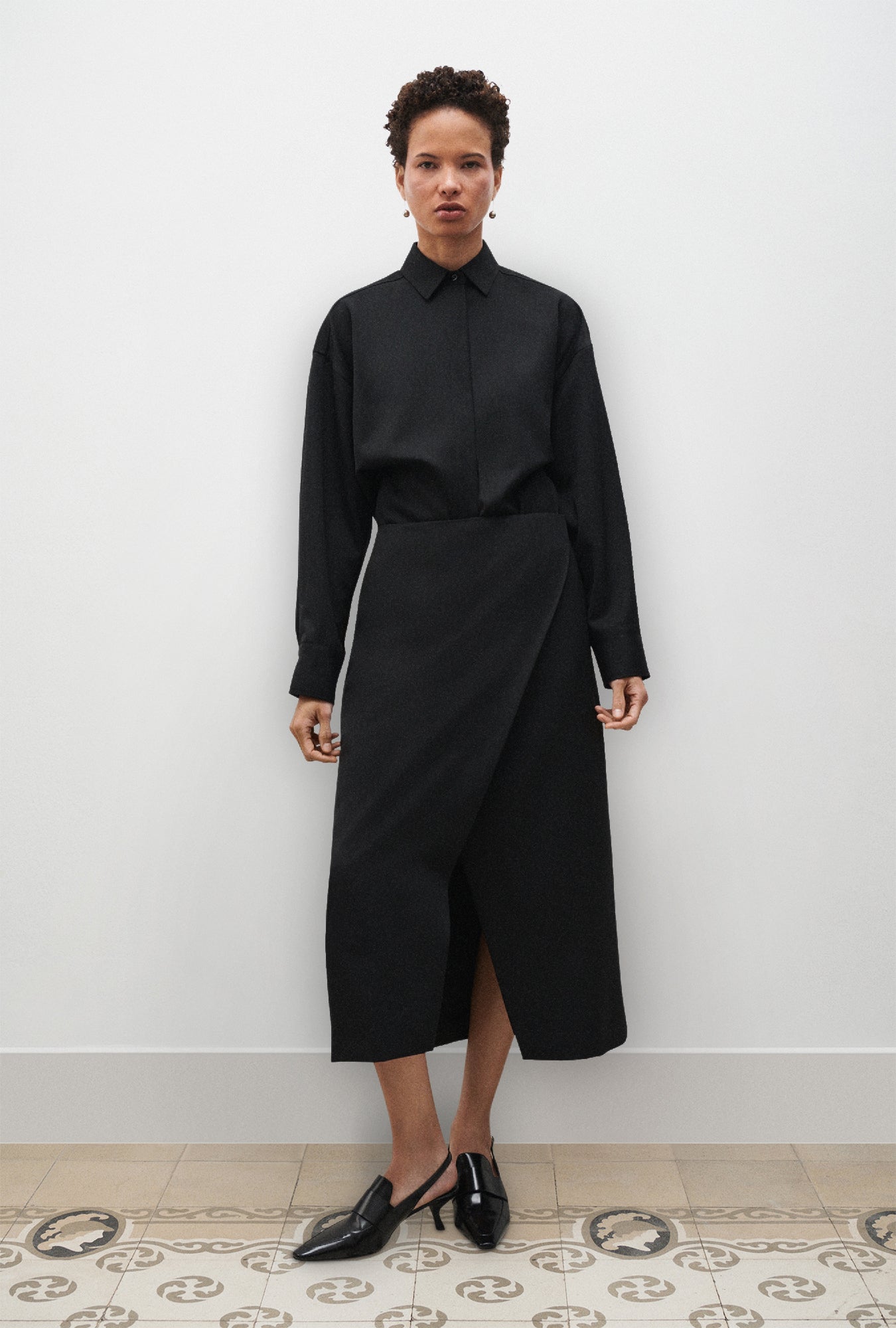 Image of a model wearing Skirts. Product name - Wool Wrap Skirt Black in Black colour by brand - Silk Laundry