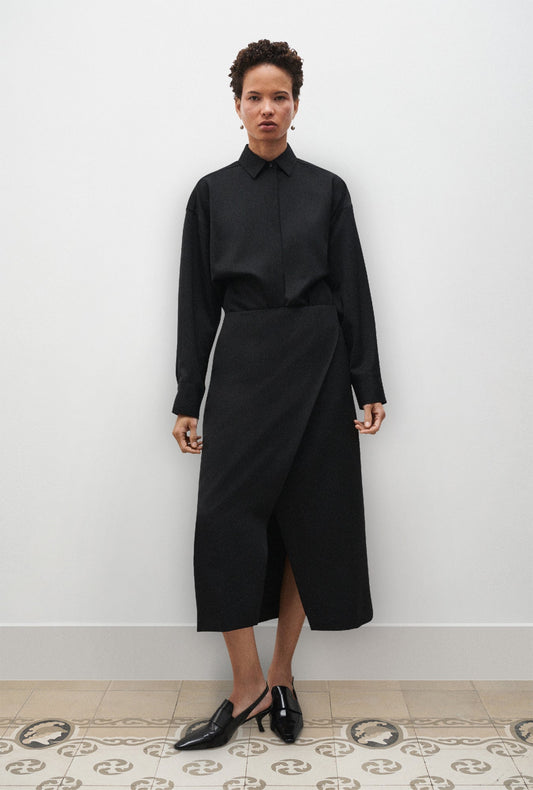 Image of a model wearing Skirts. Product name - Wool Wrap Skirt Black in Black colour by brand - Silk Laundry