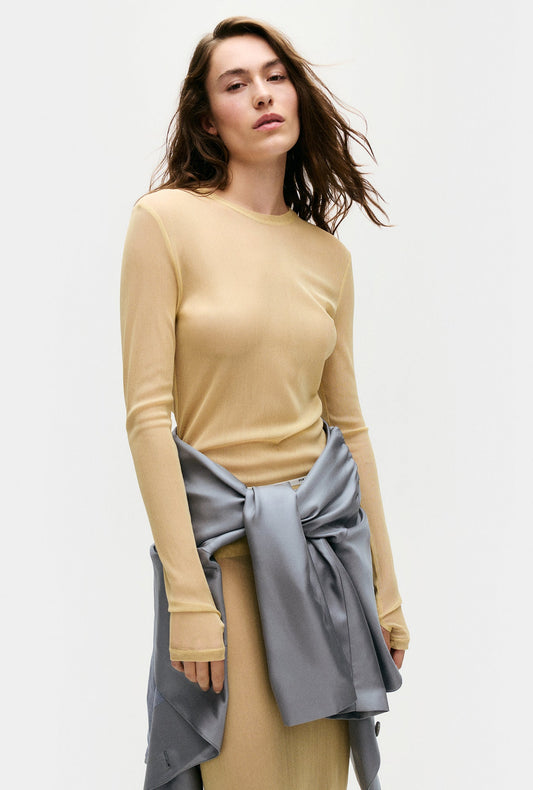Image of a model wearing Tops. Product name - Mesh Long Sleeve Top Shell in Shell colour by brand - Silk Laundry