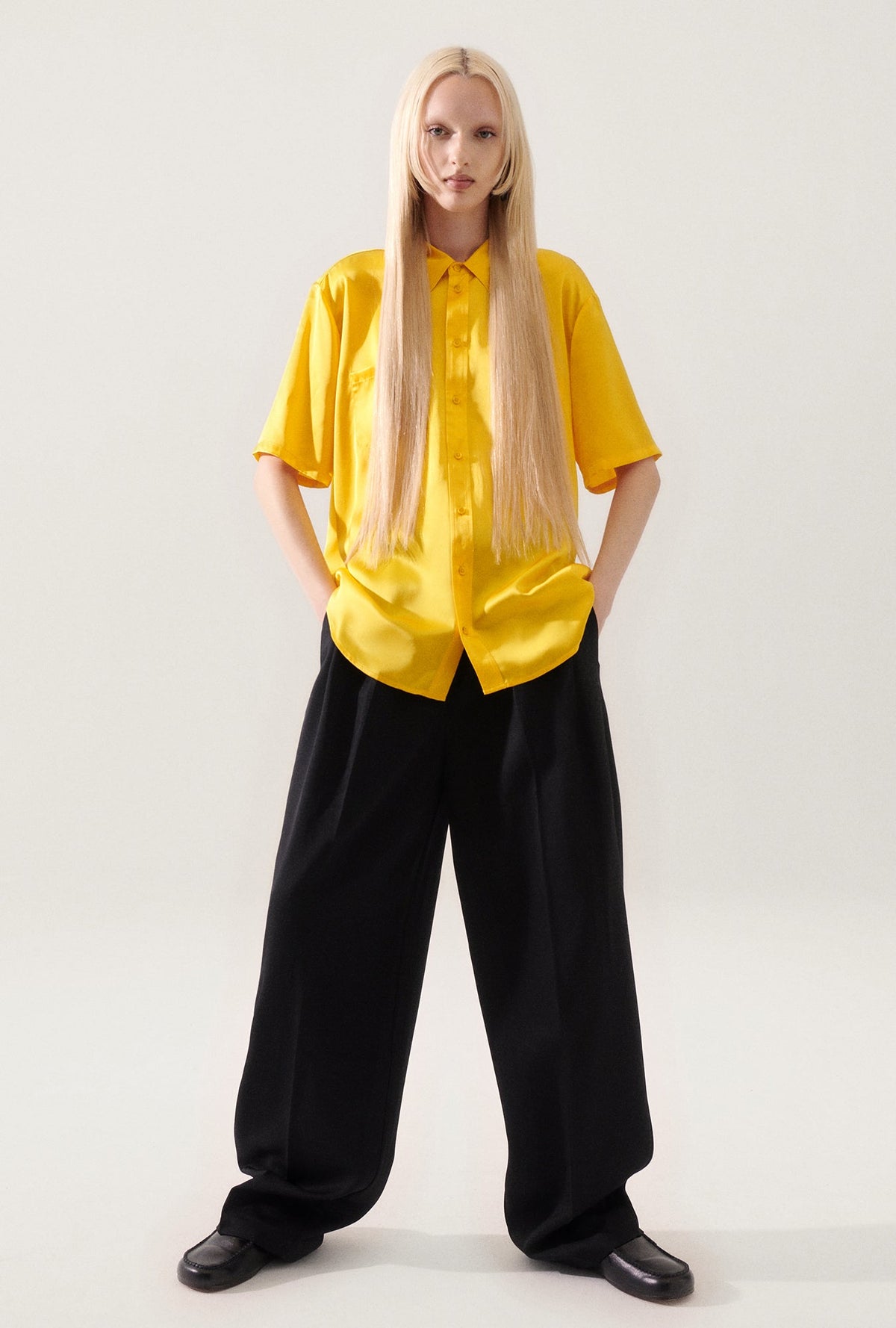 Image of a model wearing Tops. Product name - Short Sleeve Boyfriend Shirt Marigold in Marigold colour by brand - Silk Laundry