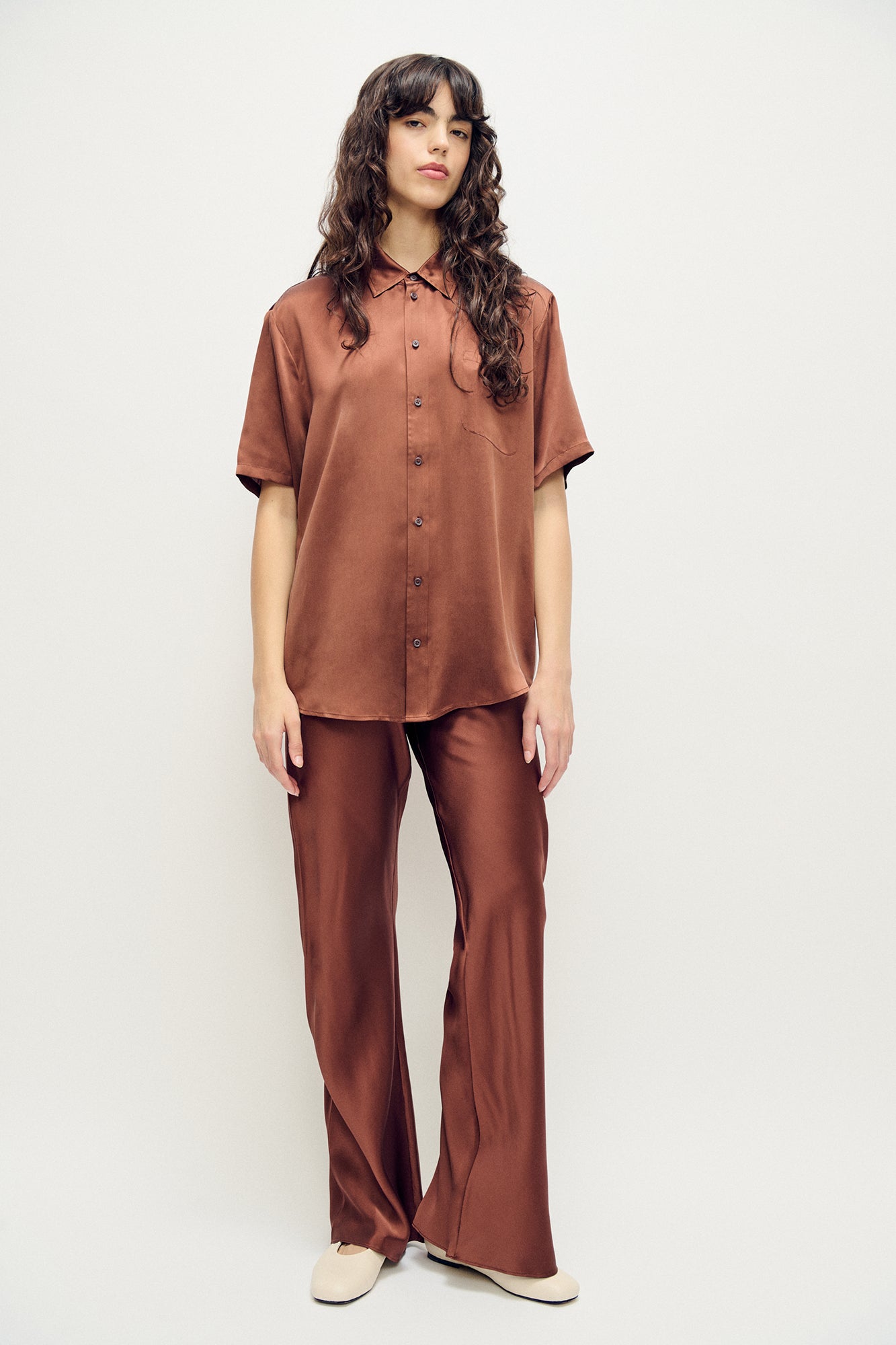 Image of a model wearing Tops. Product name - Short Sleeve Boyfriend Shirt Root in Root colour by brand - Silk Laundry