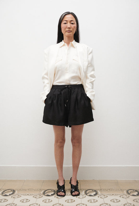 Image of a model wearing Shorts. Product name - Twill Slouch Shorts Black in Black colour by brand - Silk Laundry