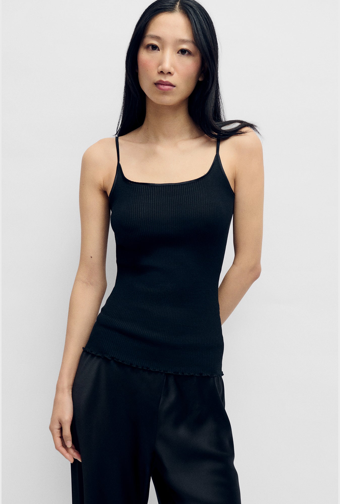 Image of a model wearing Tops. Product name - Silk Wool Ribbed Essential Cami Black in Black colour by brand - Silk Laundry
