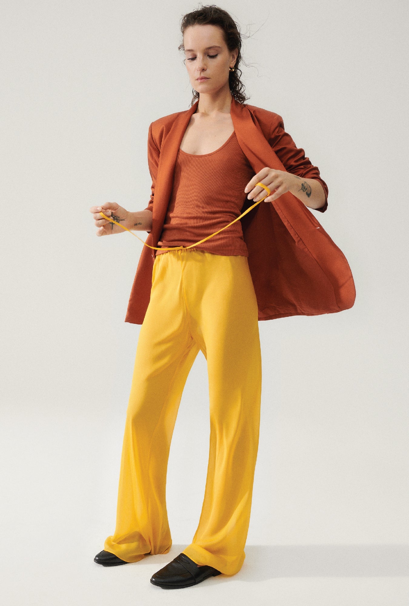 Image of a model wearing Pants. Product name - Chiffon Bias Cut Pants Goldfinch in Goldfinch colour by brand - Silk Laundry