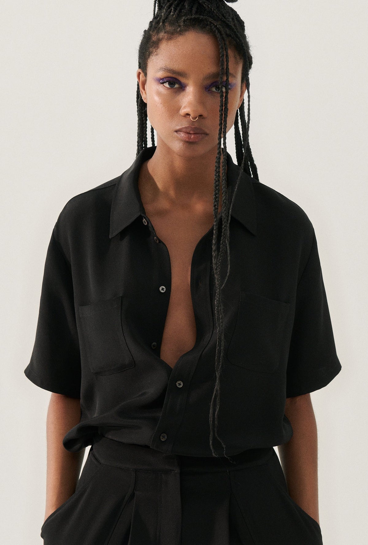 Image of a model wearing Tops. Product name - CDC Short Sleeve Boyfriend Shirt Black in Black colour by brand - Silk Laundry