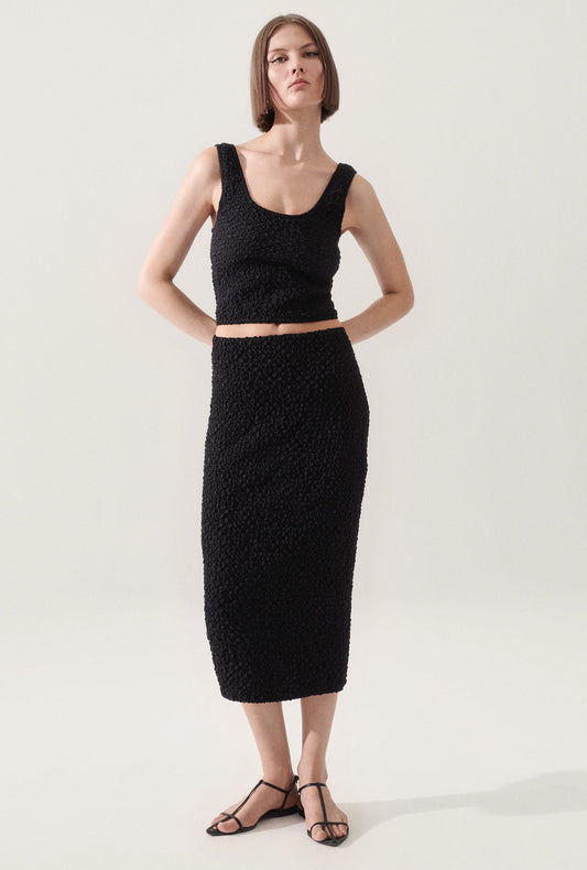 Image of a model wearing Skirts. Productname: Popcorn Midi Skirt Black in Black colour by brand - Silk Laundry
