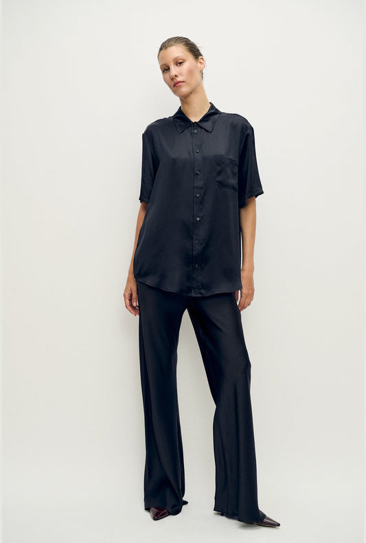 Image of a model wearing Tops. Product name - Short Sleeve Boyfriend Shirt Black in Black colour by brand - Silk Laundry