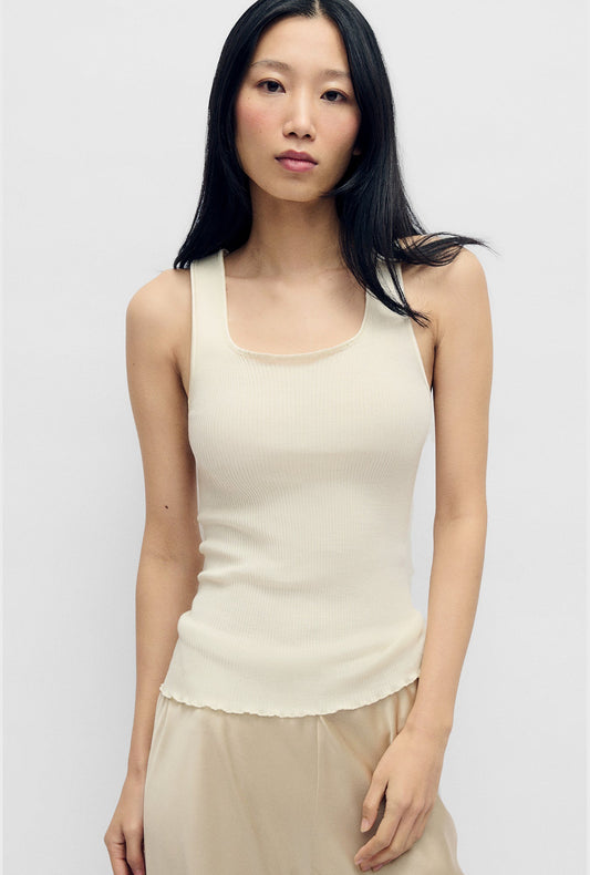 Image of a model wearing Tops. Product name - Silk Wool Ribbed Essential Tank White in White colour by brand - Silk Laundry