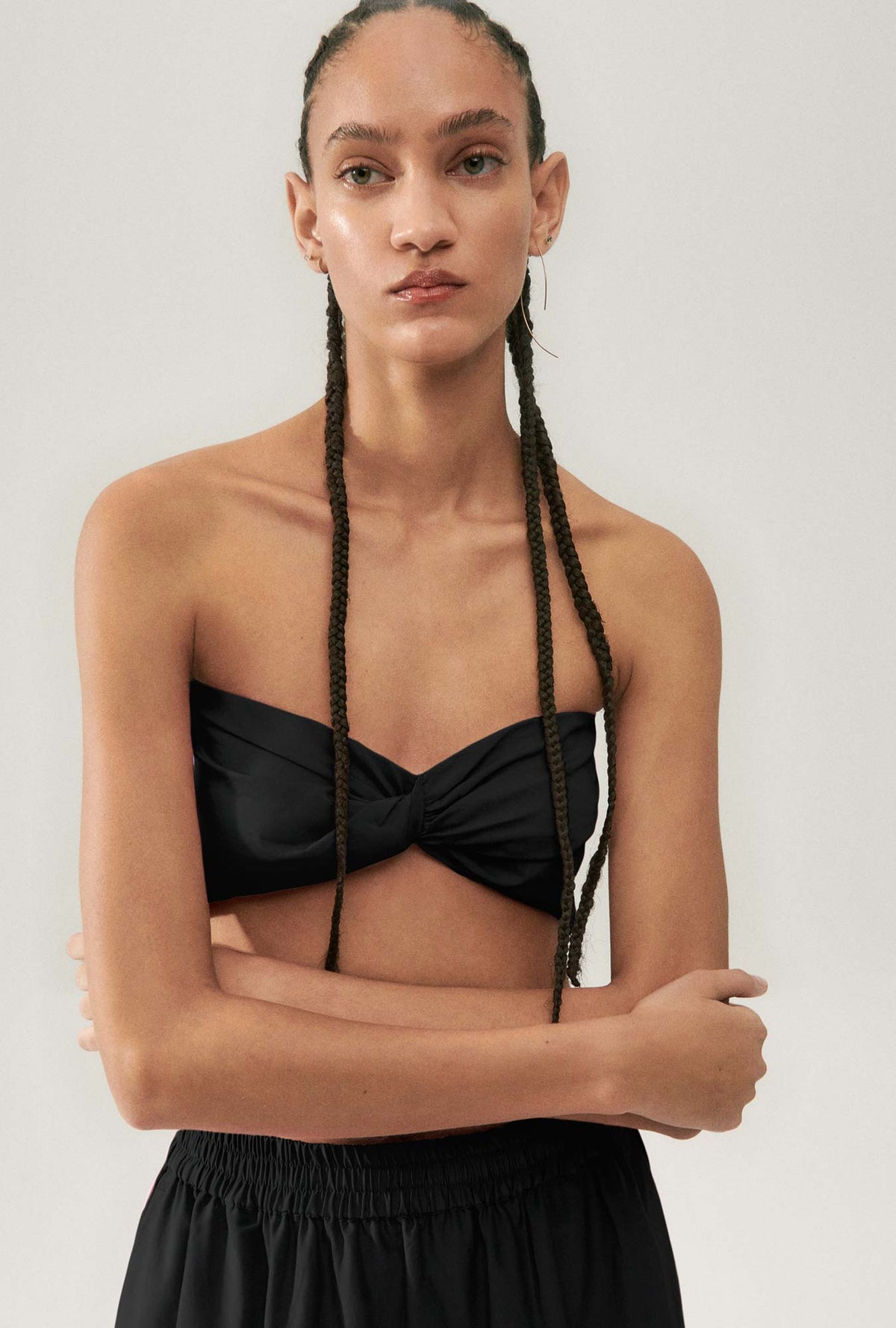 Image of a model wearing Tops. Product name - Cotton Silk Twist Top Black in Black colour by brand - Silk Laundry