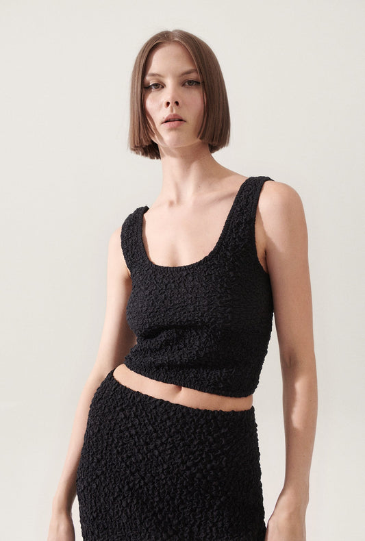 Image of a model wearing Tops. Productname: Popcorn Cropped Cami Black in Black colour by brand - Silk Laundry