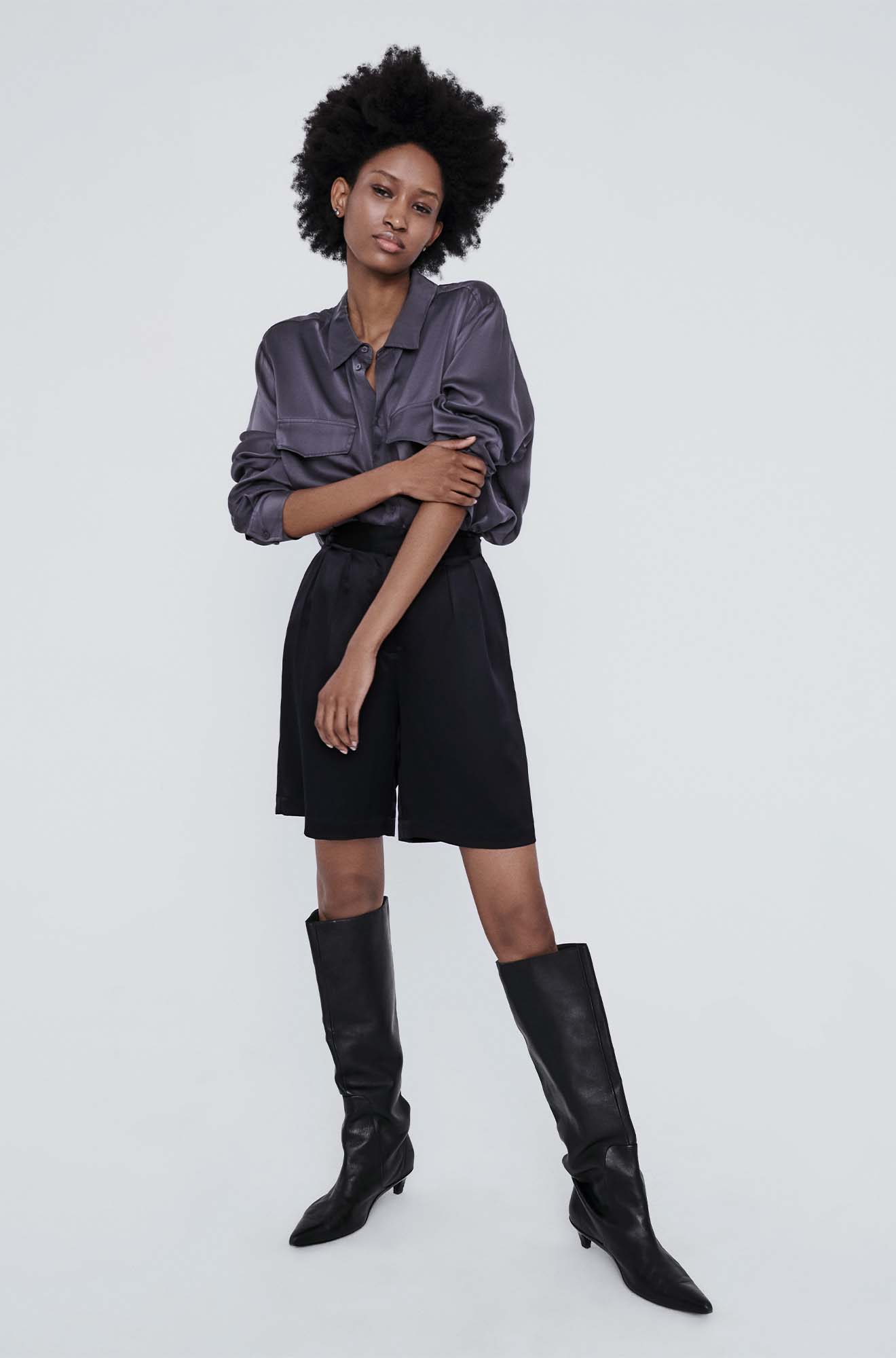 Image of a model wearing Shorts. Product name - Double Pleated Shorts Black in Black colour by brand - Silk Laundry