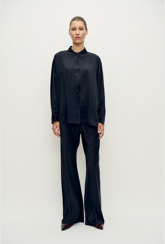 Image of a model wearing Pants. Product name - Bias Cut Pants Black in Black colour by brand - Silk Laundry