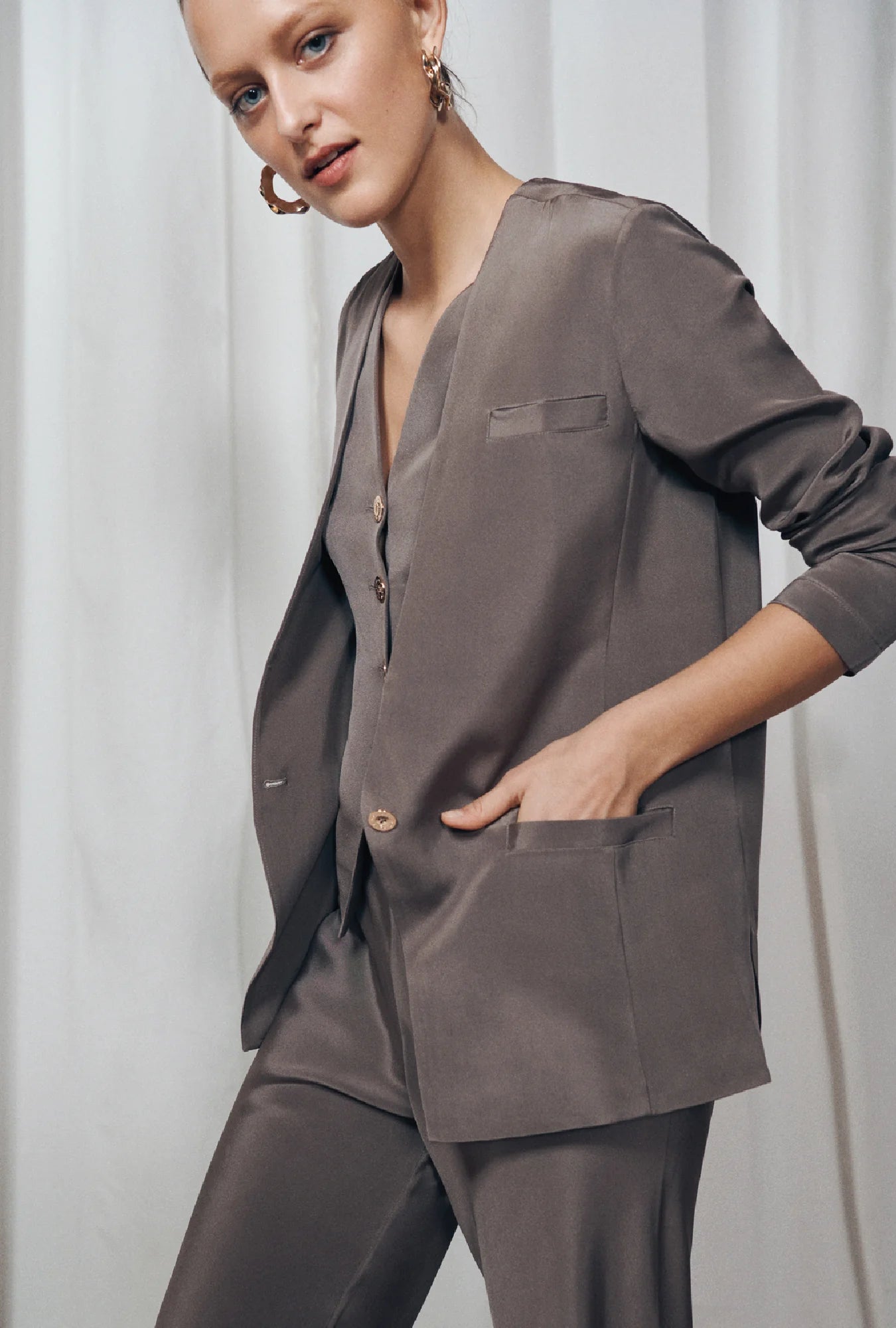 Image of a model wearing Outerwear. Product name - CDC Collarless Blazer Cinder in Cinder colour by brand - Silk Laundry