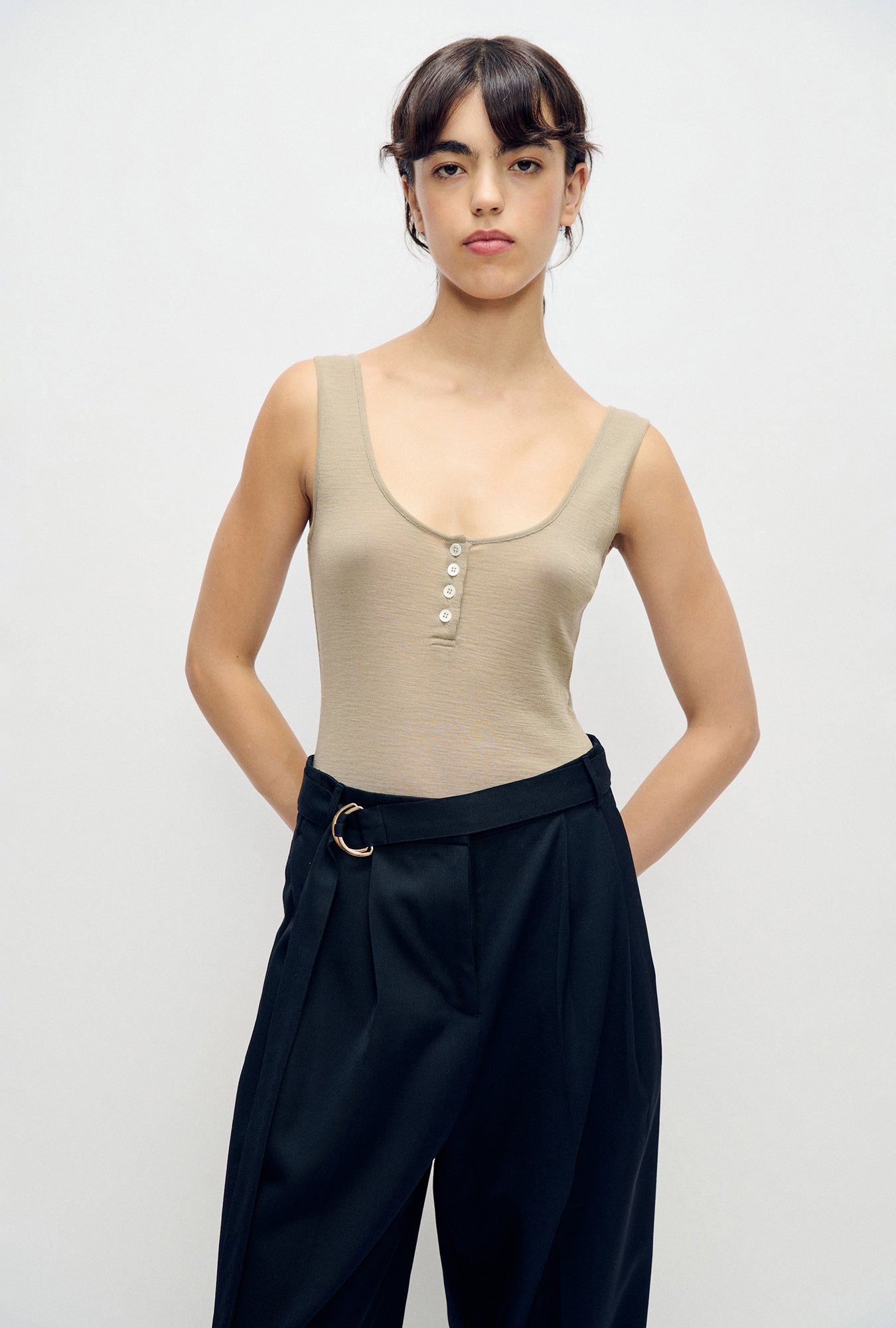 Image of a model wearing Tops. Product name - Merino Henley Tank Saddle in Saddle colour by brand - Silk Laundry