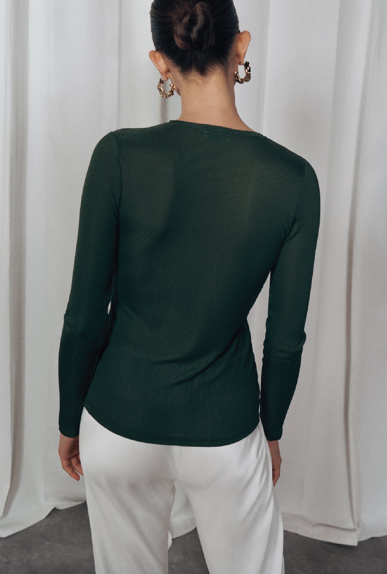 Image of a model wearing Tops. Product name - Ribbed Long Sleeve Henley Cedar in Cedar colour by brand - Silk Laundry