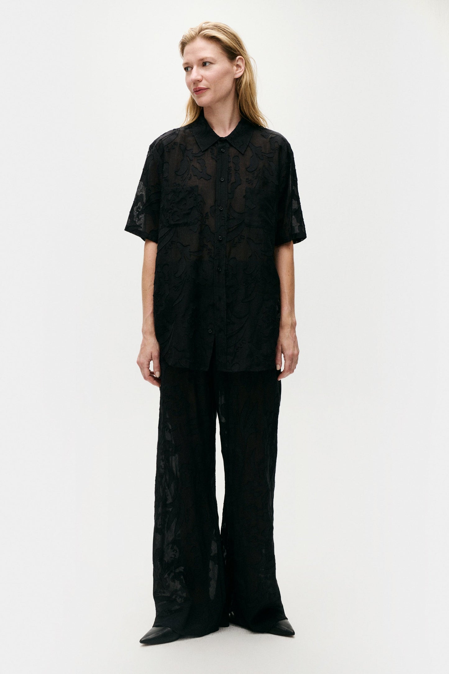 Image of a model wearing Tops. Product name - Clip Silk Short Sleeve Boyfriend Shirt Black in Black colour by brand - Silk Laundry