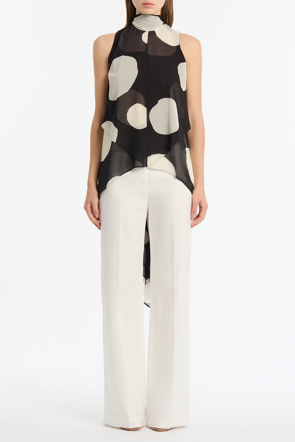 Image of a model wearing Tops. Product name - Noir Spot Tie Neck Top in Black colour by brand - Carla Zampatti