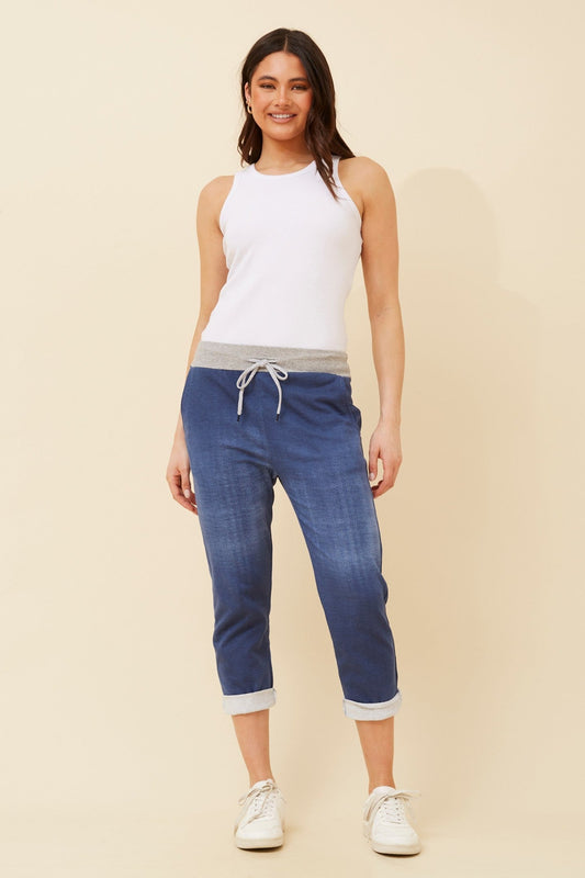 Image of a model wearing Pants. Product name - GINNA DENIM JOGGER PANTS in Dark Denim colour by brand - BOTTEGA MODA