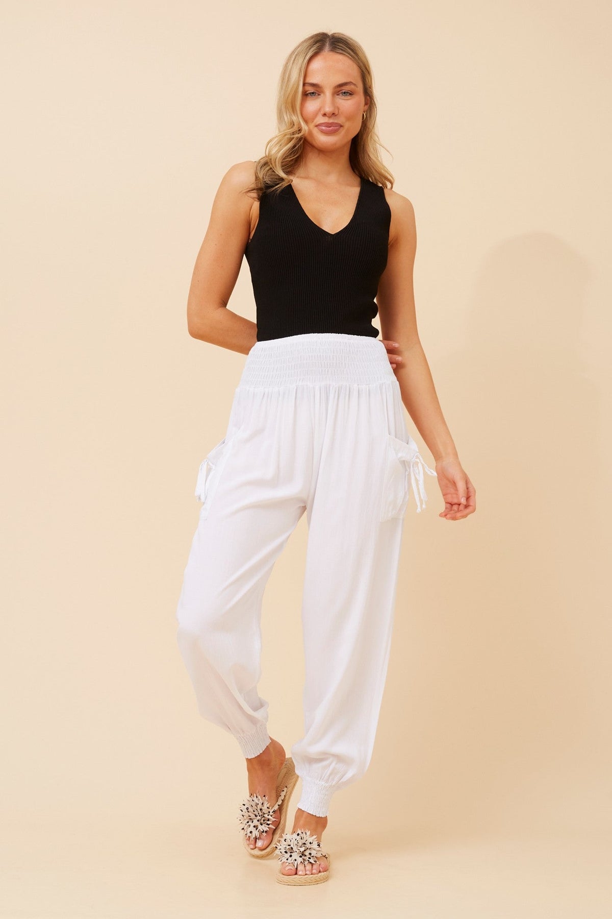 Image of a model wearing Pants. Product name - SOLID HAREM PANTS in White colour by brand - Caroline Morgan Australia