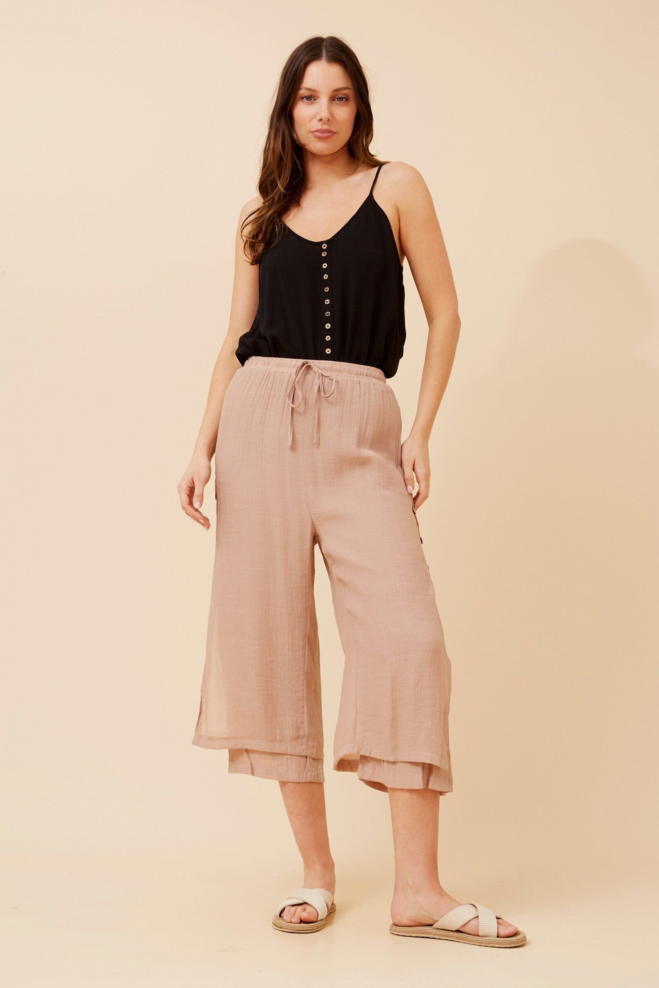 Image of a model wearing Pants. Product name - DAMIANA BUTTON DETAIL CULOTTES in Black colour by brand - Caroline Morgan Australia