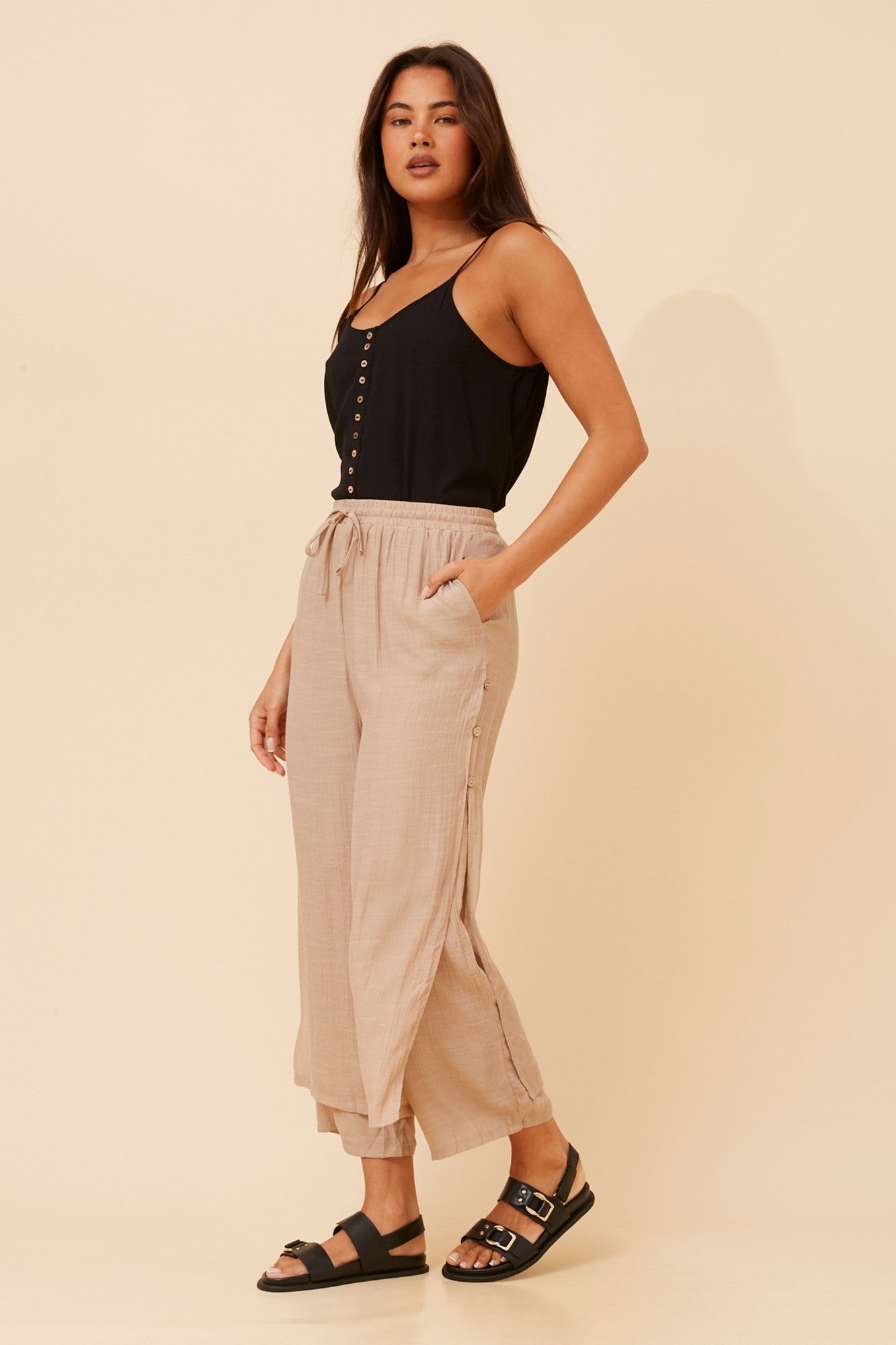 Image of a model wearing Pants. Product name - DAMIANA WIDE LEG PANTS in Black colour by brand - Caroline Morgan Australia
