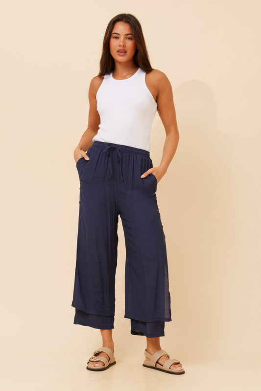Image of a model wearing Pants. Product name - DAMIANA WIDE LEG PANTS in Navy colour by brand - Caroline Morgan Australia